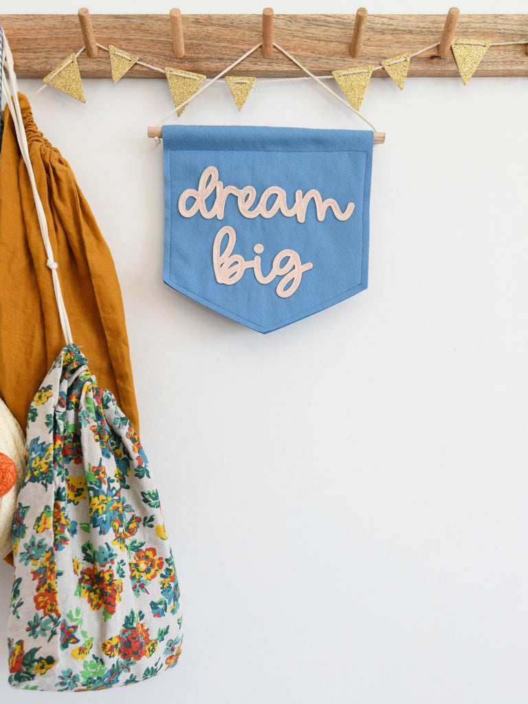 felt banner with the words dream big sewn on in cursive font.