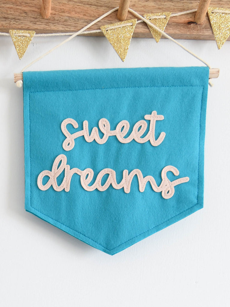 mini felt banner with the words sweet dreams sewn on in cursive font.