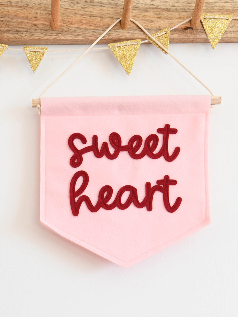 mini felt banner with the word sweet heart sewn on in cursive font.