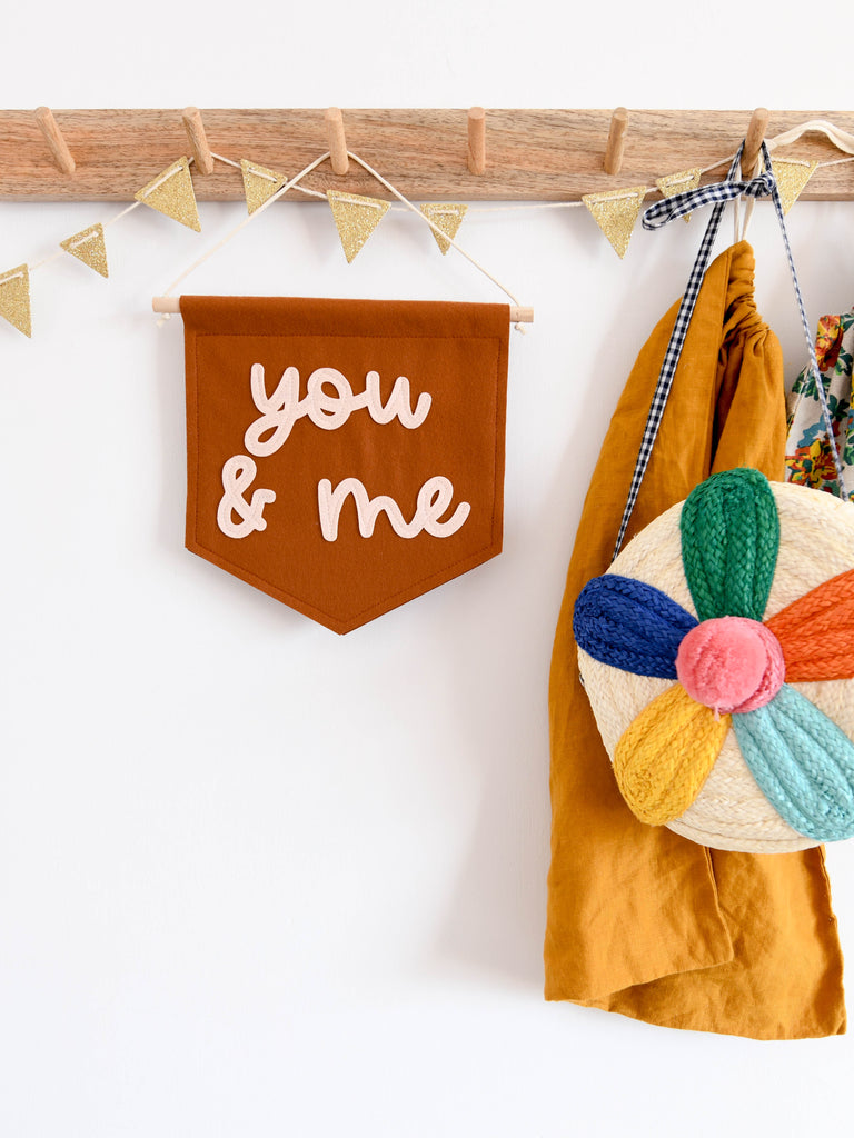 mini felt banner with the words you and me sewn on in cursive font.